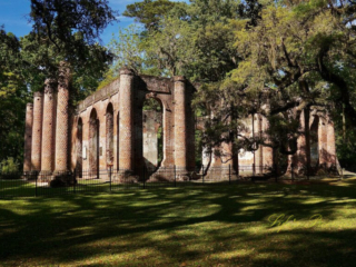 Side view of the Old Sheldon Church ruins. Trees surround the structure.