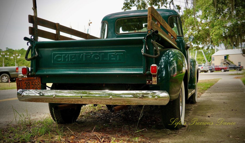 Close up rear view of a 1953 dark green Chevrolet 3100 truck.