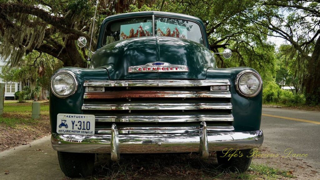 Front view of a classic dark green 1953 Chevrolet 3100 truck.