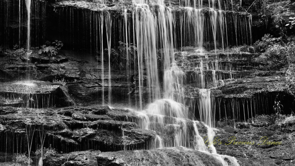 Black and white close up of Station Cove Falls spilling over the rocks.