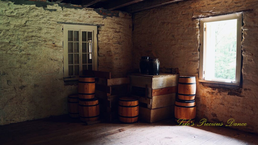 Stacked barrels and jugs on a wooden table inside a stone blockhouse at Oconee Station.