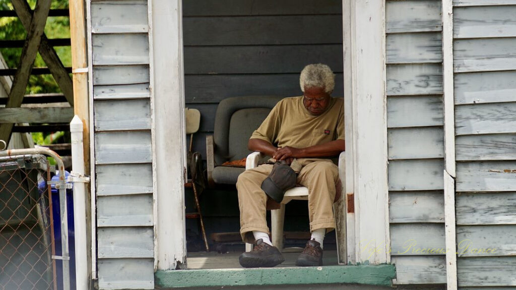 Man sleeping on a porch.