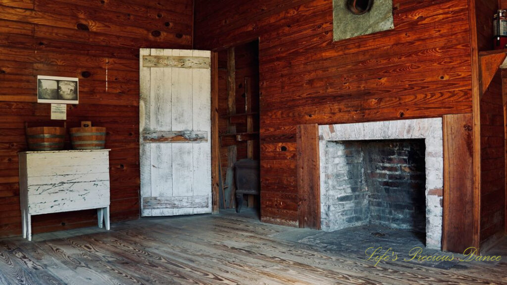 Inside view of the servant quarters at Redcliffe Plantation. Fireplace to the right, closet in the middle and an old table with buckets on top to the left.