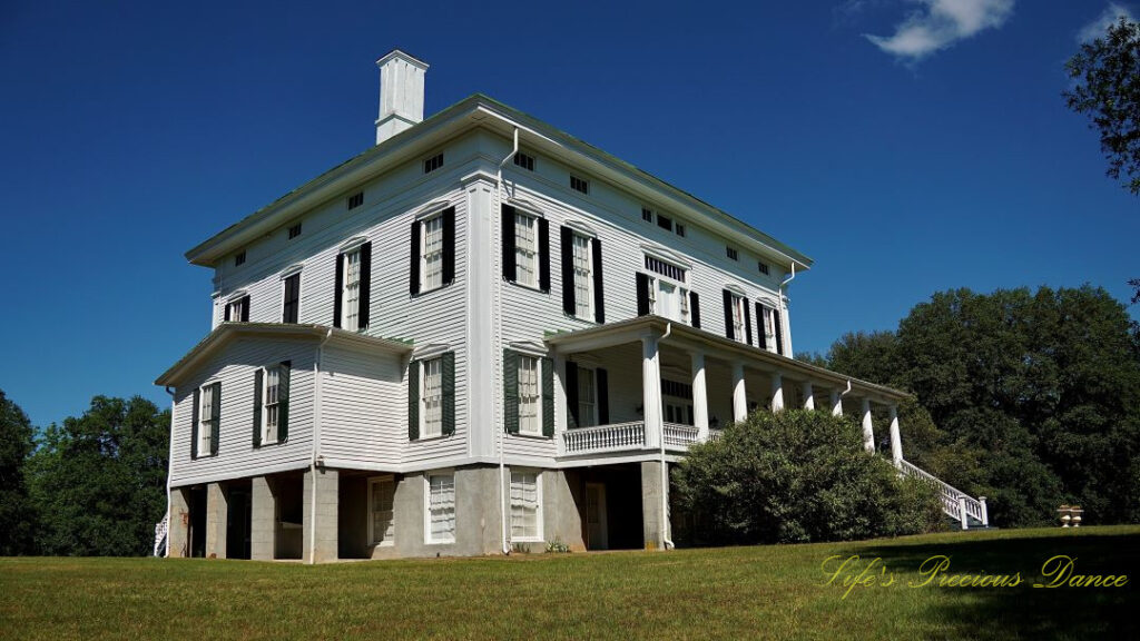 Looking upward at the Redcliffe Plantation mansion. Blue skies overhead.