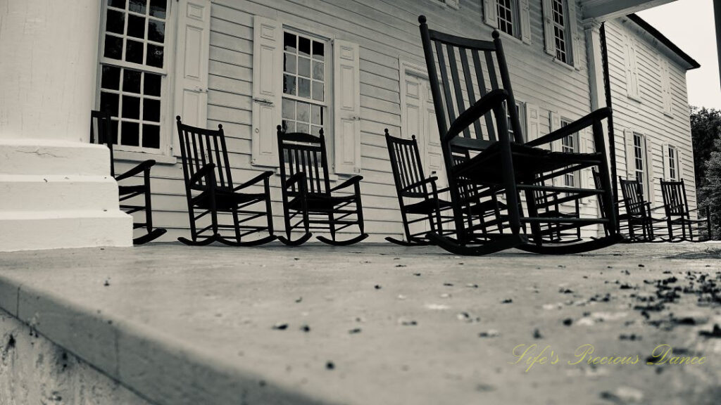 Ground level black and white view of rocking chairs on the mansion porch at Hampton Plantation.