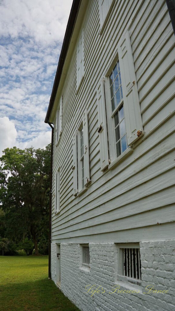 Looking upward at left side of Hampton Plantation Mansion. Passing clouds overhead.