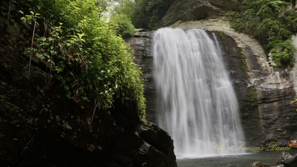 Looking Glass Falls spilling down a rockface into the awaiting creek below