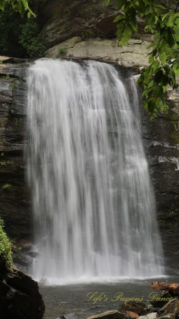 Looking Glass Falls pouring down a rockface into the awaiting mountain stream below.