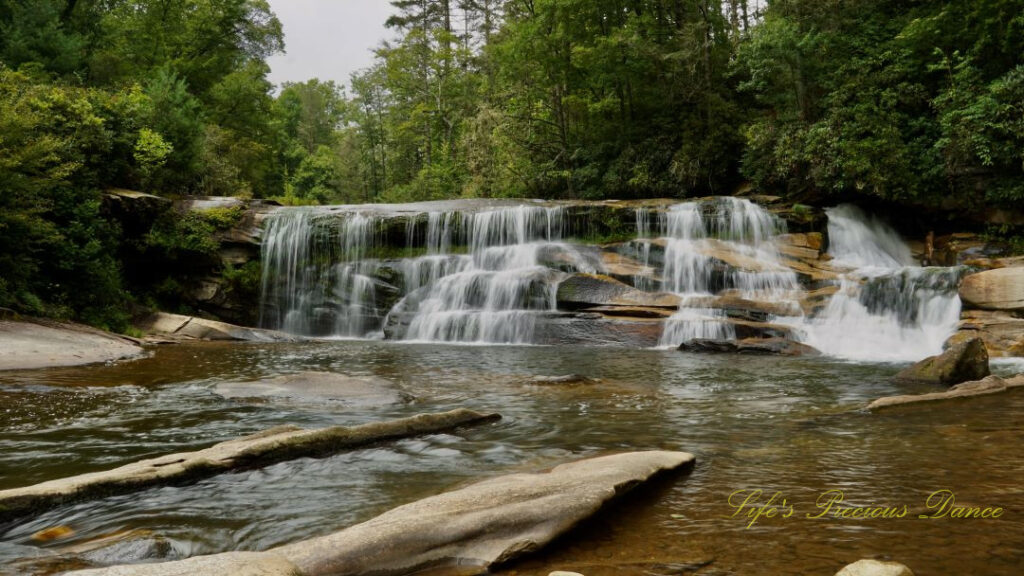 The French Broad Falls spilling over a rockface into the river below.