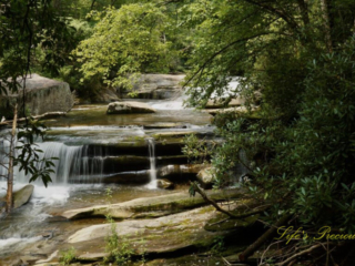 The upper section of Bird Rock Falls flowing over and through the rocks of the French Broad River.
