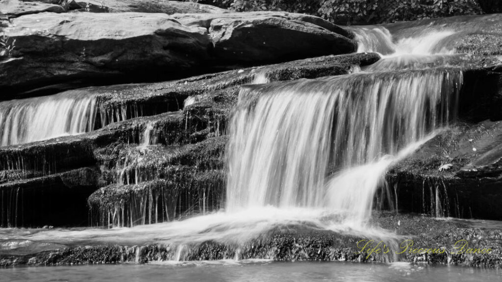 Black and white close up of Horseshoe Falls spilling over rocks into the Enoree River.