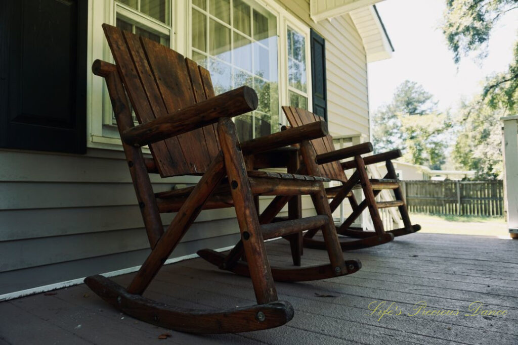 Looking upward at wooden rocking chairs on a porch.