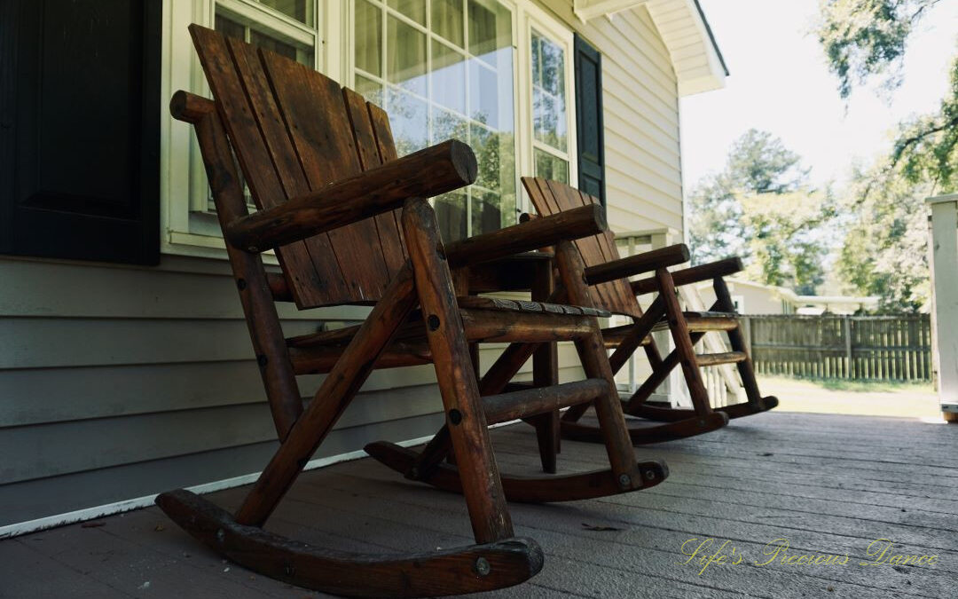 Looking upward at wooden rocking chairs on a porch.