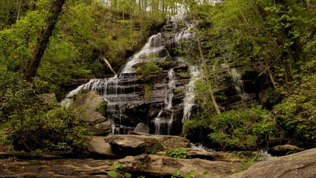 Issaqueena Falls spilling down a jagged rockface into a pool of water below.