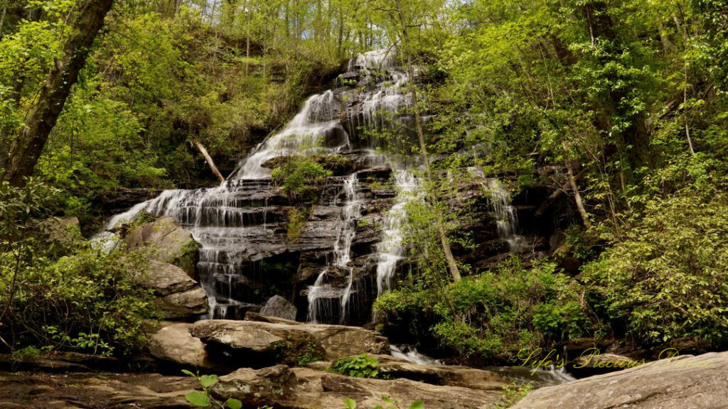 Issaqueena Falls spilling down a jagged rockface into a pool of water below.