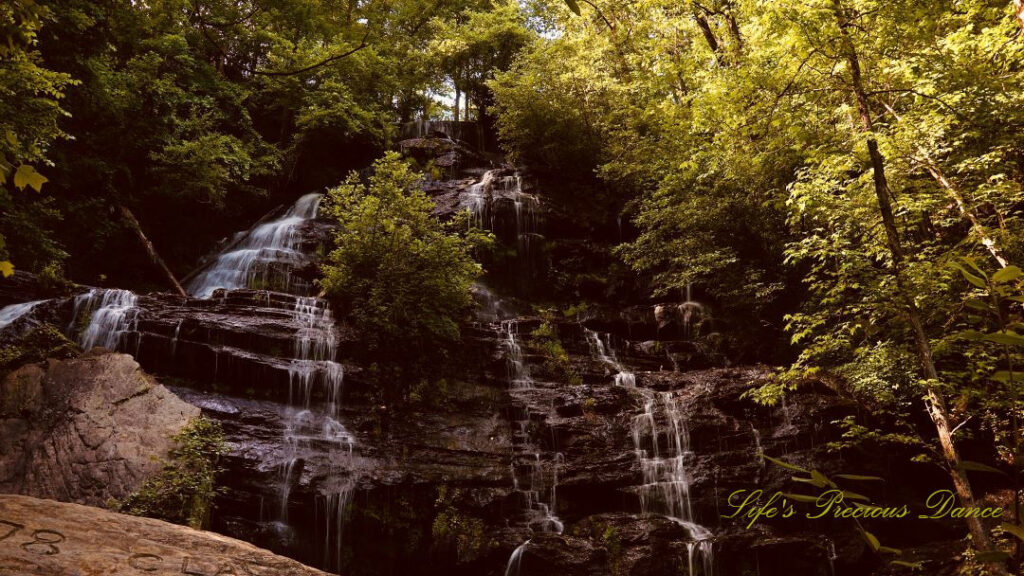 Issaqueena Falls spilling down a jagged rockface, surrounded by golden colored foliage.