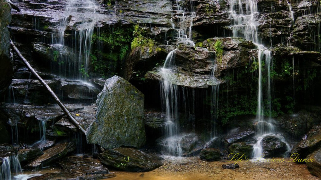 Close up of the lower section of Issaqueena Falls, spilling over the jagged rockface into a pool of water below.