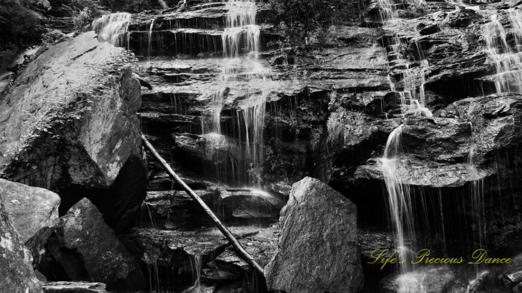 Close up black and white of Issaqueena Falls spilling down the jagged rock face.