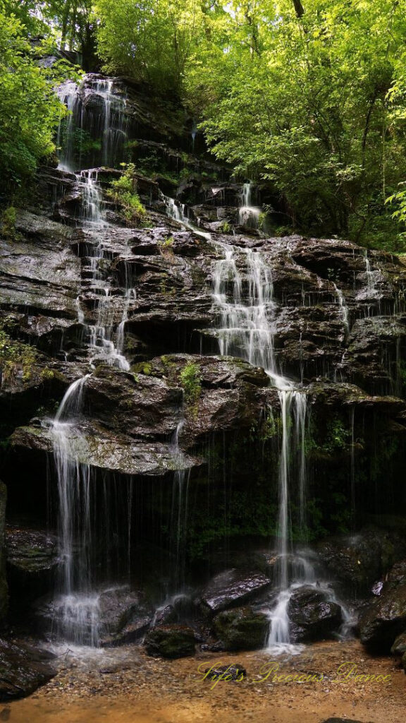 Issaqueena Falls spilling down the jagged rockface into a pool of water below.