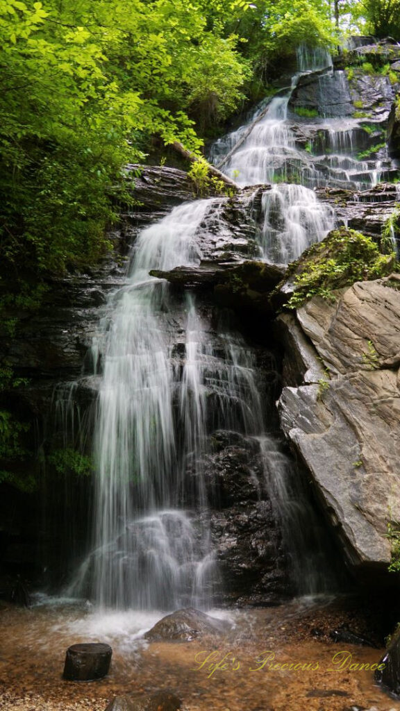 Issaqueena Falls spilling down the jagged rockface into a pool of water below.