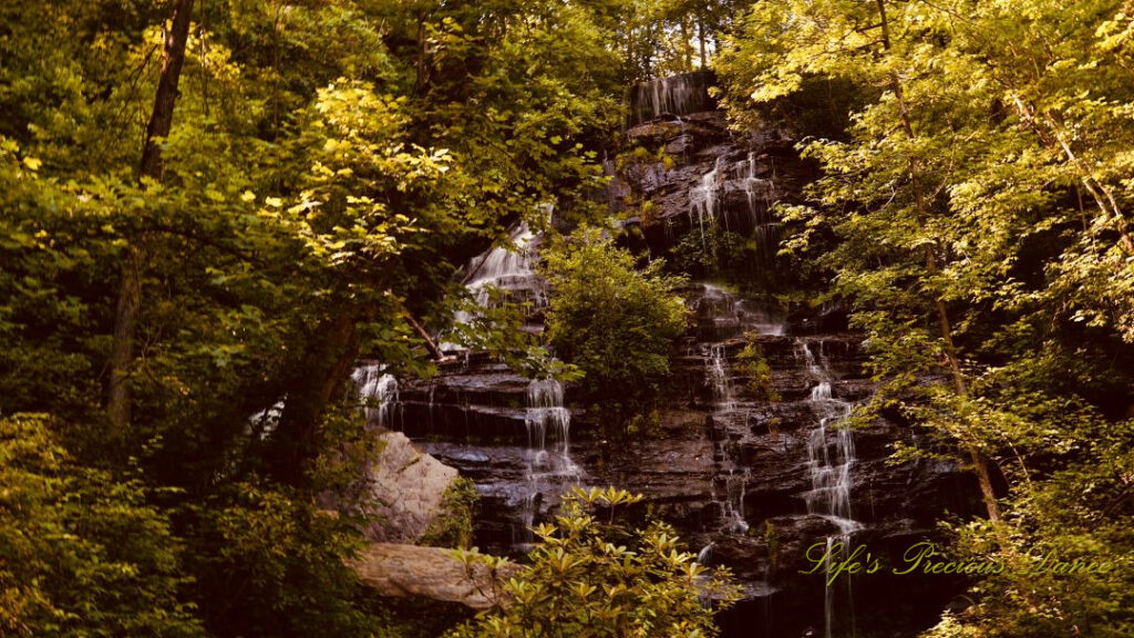 Issaqueena Falls spilling down a jagged rockface, surrounded by golden colored foliage.