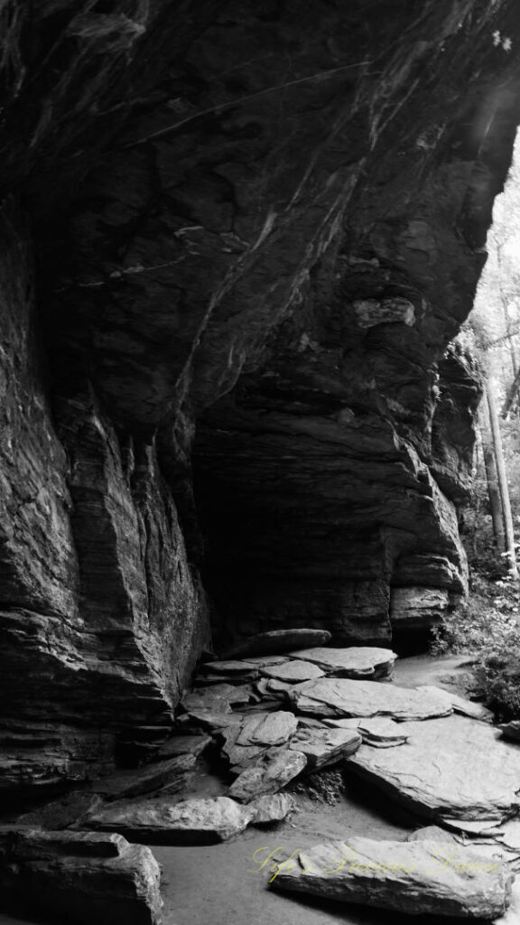 Black and white of the underside of the rock mountain below Moore Cove Falls.