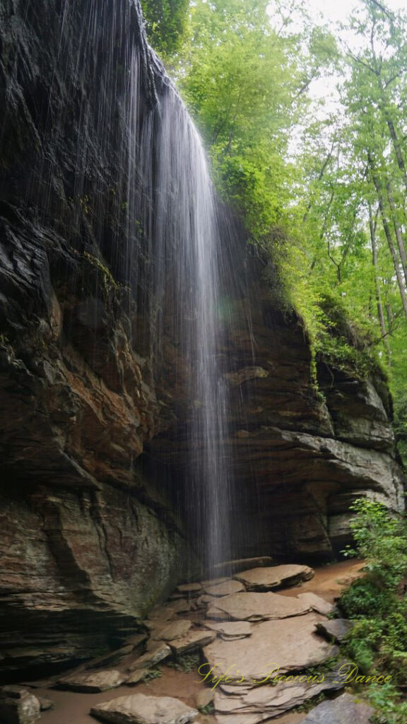 Moore Cove Falls spilling over the rock ledge into a pool of water below.