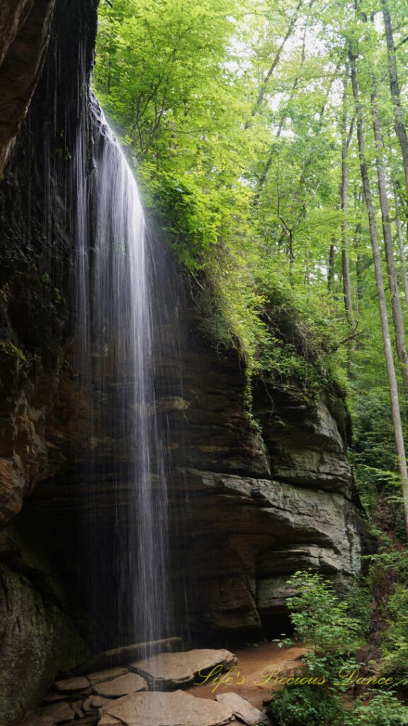 Side view of Moore Cove Falls spilling over the rock ledge into a mountain stream below.