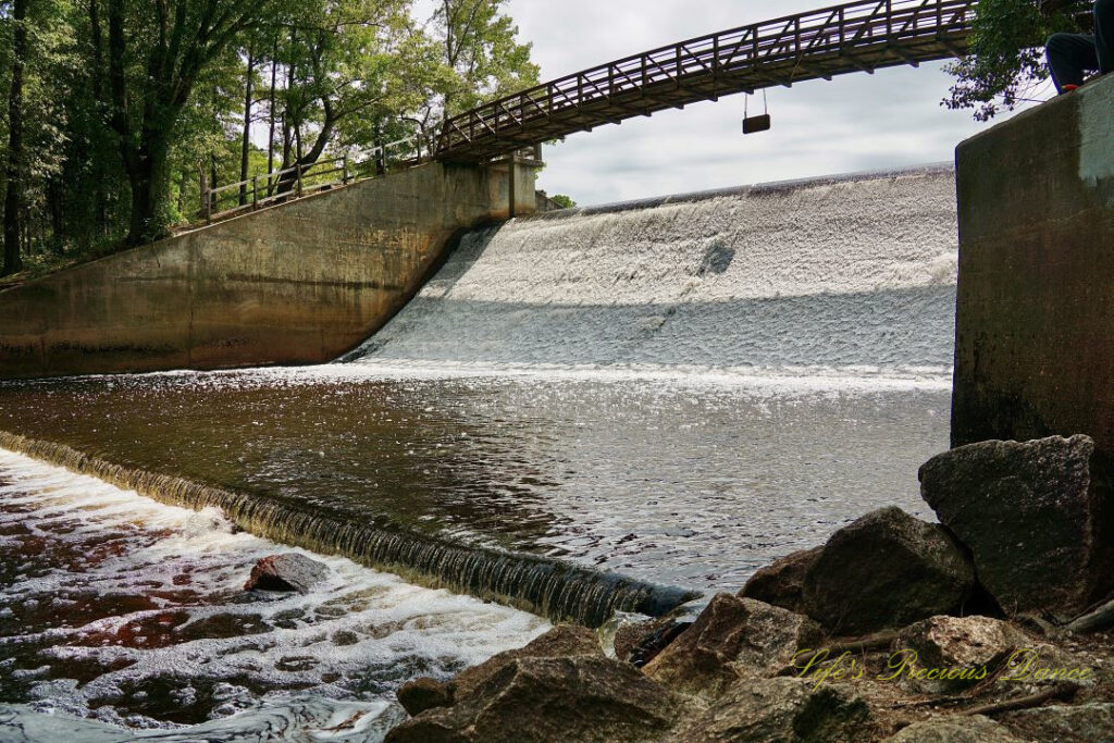 Looking up from the bank of Juniper Creek at the walking bridge crossing the spillway.