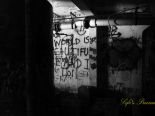Black and white view of the graffiti covered pump room, located below the water level at abandoned Springs pool.
