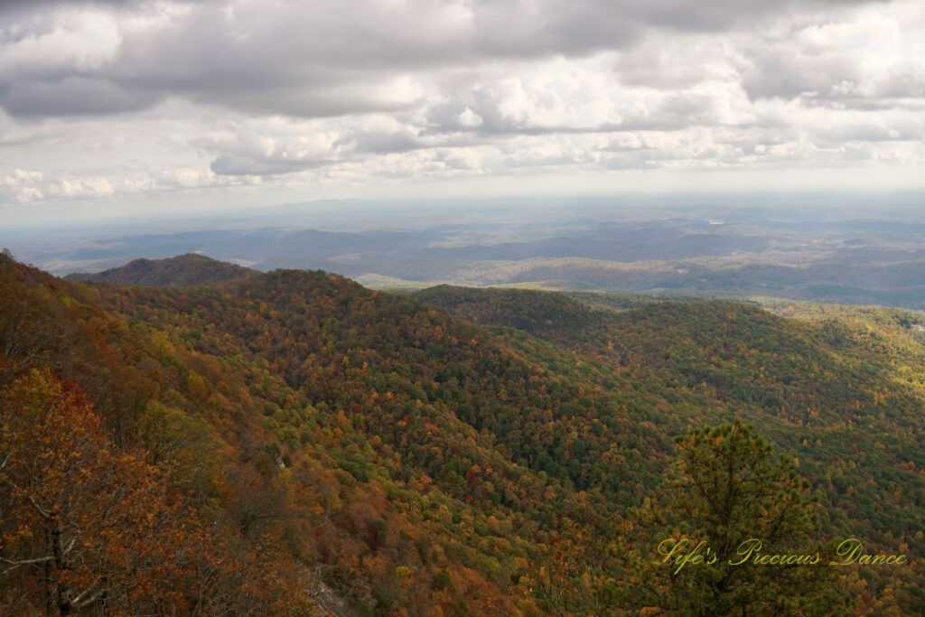 Landscape view from Caesars Head Overlook. The sun&#039;s rays cascading through overhead passing clouds.