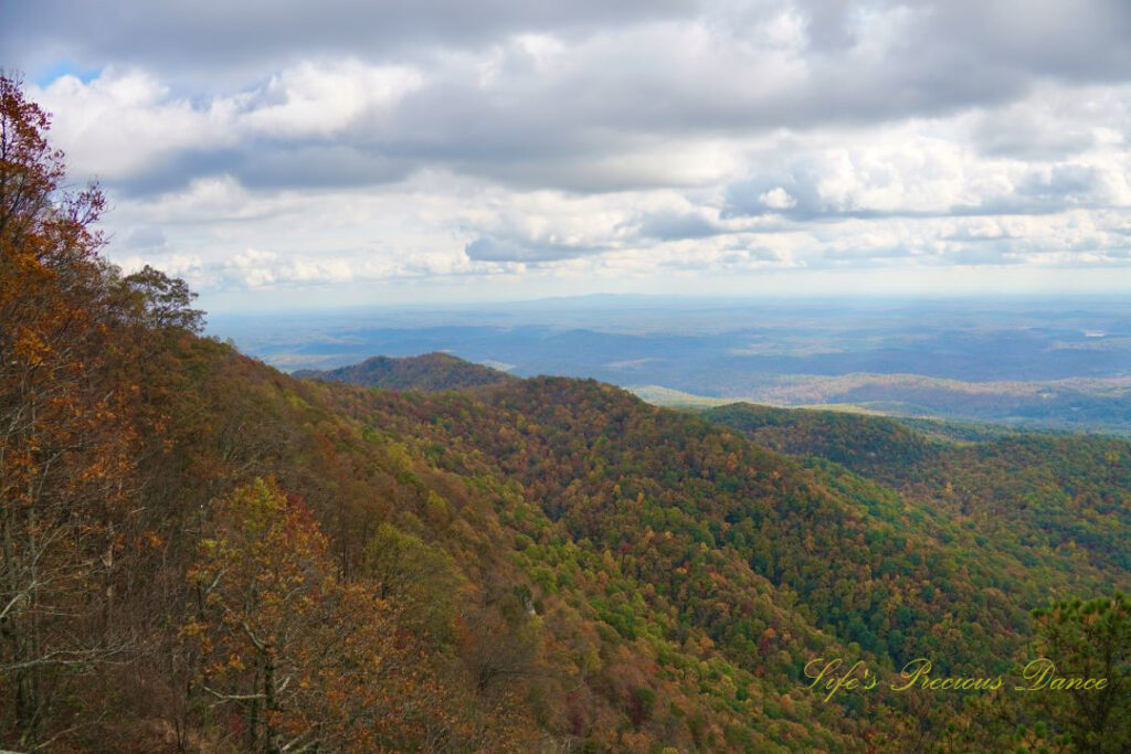 Landscape view from Caesars Head Overlook. Passing clouds overhead the colorful mountain side.