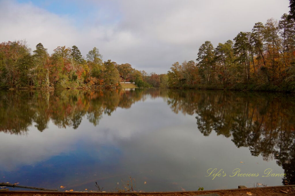 Waterscape view of Lake Placid. Colorful trees and clouds reflecting on the waters surface.