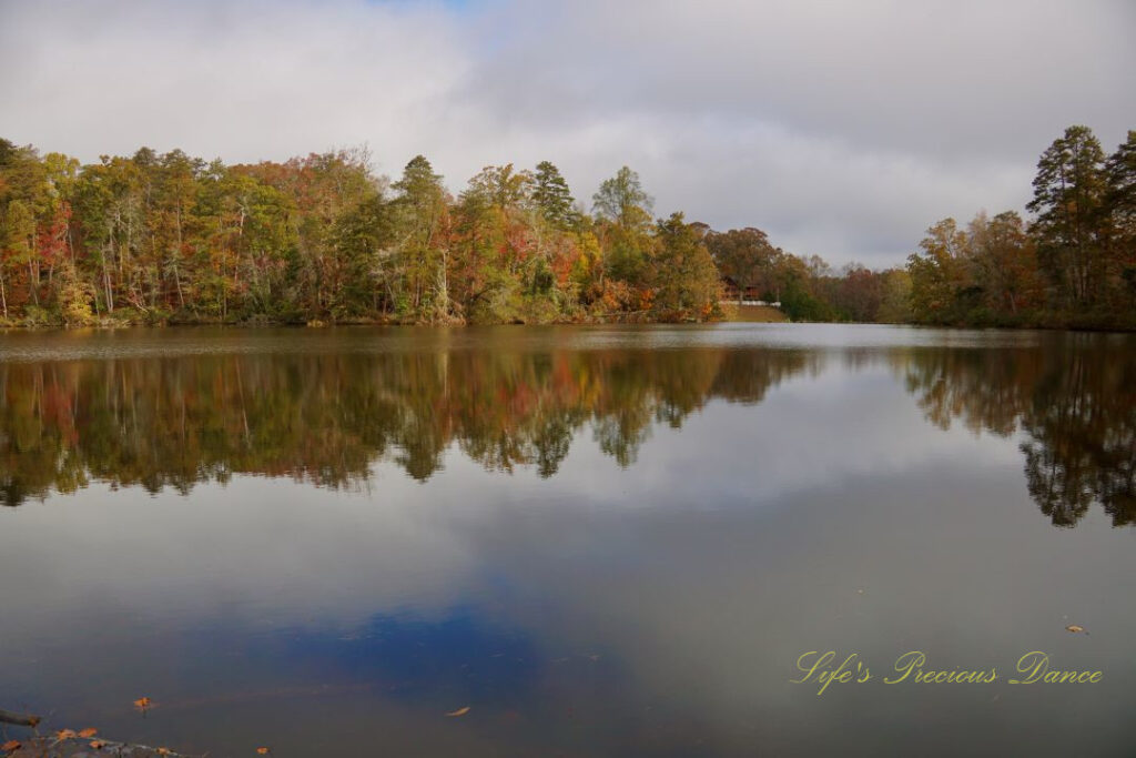 Waterscape view of Lake Placid. Colorful trees and clouds reflecting on the waters surface.